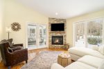 Living room with a Smart TV, seasonal gas fireplace, and access to the sunroom and patio